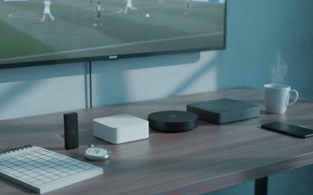 Five streaming devices, a notebook scoring grid and a stopwatch in front of a TV showing a football match